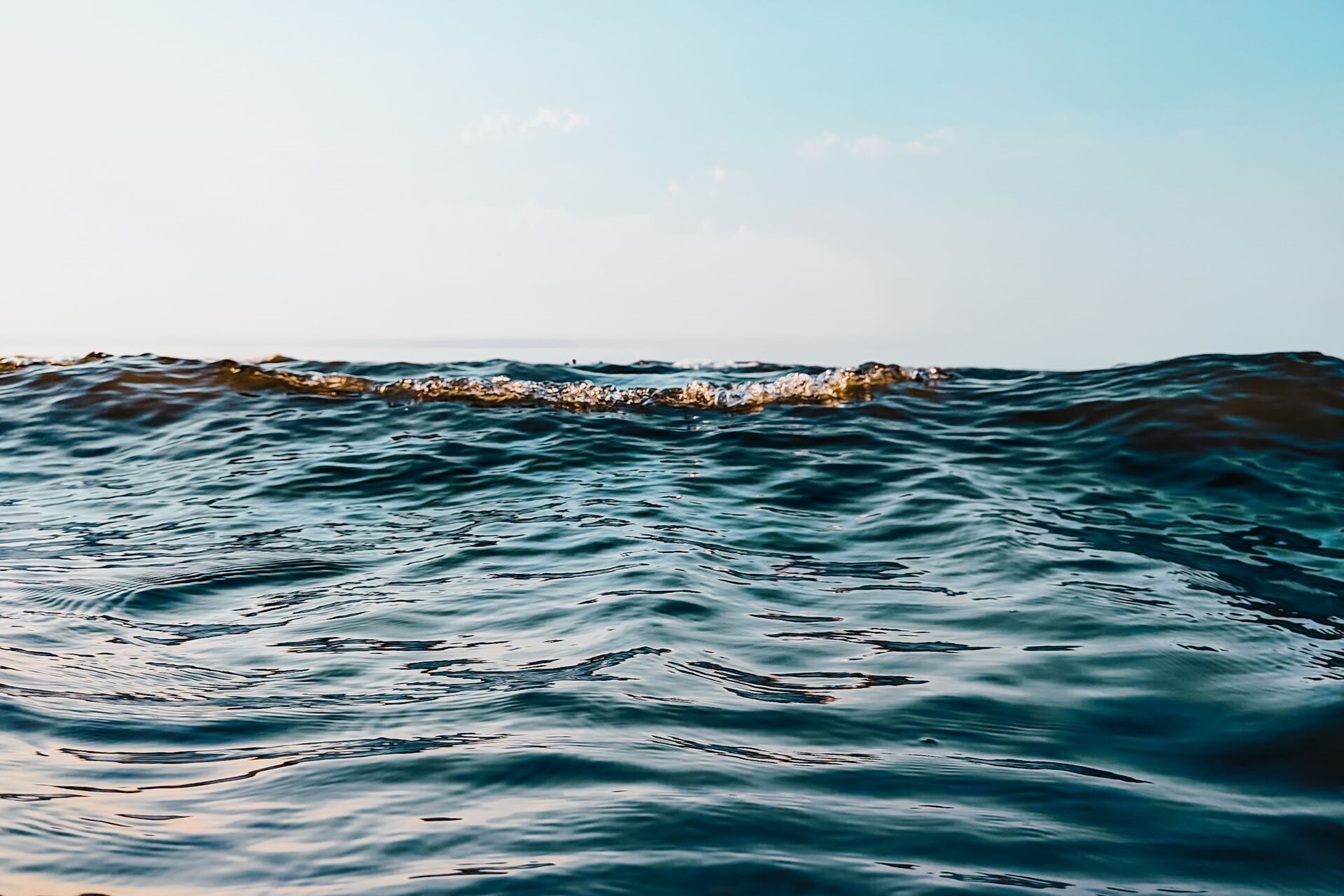 Peaceful ocean waves under a clear sky at sunset in Fereydunkenar, Iran.