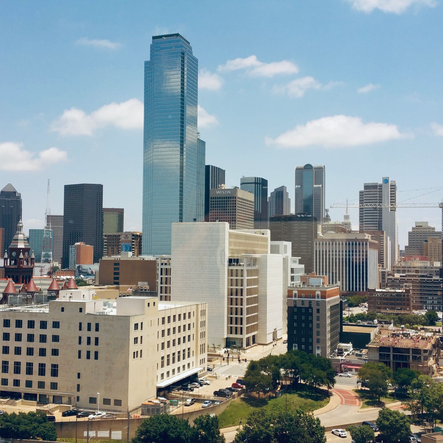 Aerial view of Dallas skyline featuring modern skyscrapers under a clear blue sky.
